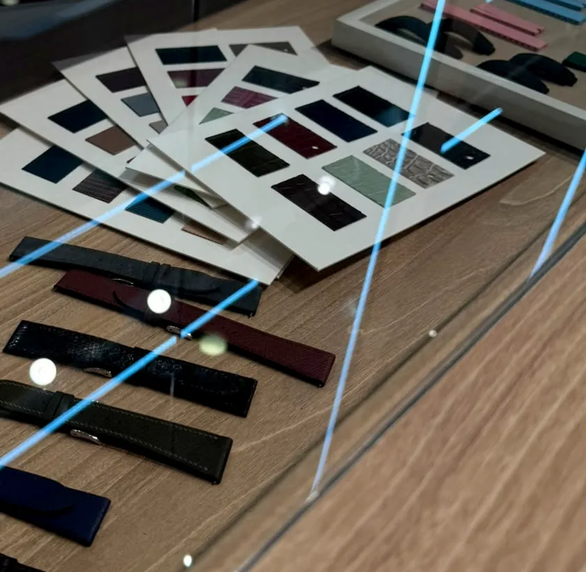 Leather straps and fanned swatch cards laid out in the display case